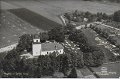 Flygfoto av Östads kyrka. Odaterat. Förlag David Carlsson, Sjövik. A B Almquist Cöster, Hälsingborg. Foto Lilljqvist
